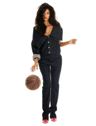 Model Jessie Aina in a dark denim set with an exaggerated folded collar posing with a basketball on a white background.