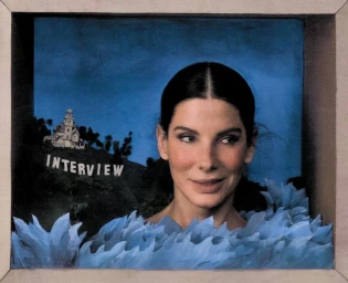Sandra Bullock framed in a diorama box with sculpted blue paper waves and a miniature Hollywood hill reading INTERVIEW.