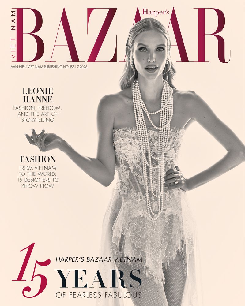 Leonie Hanne posing for Harper's Bazaar Vietnam cover wearing a strapless white lace corset dress and layered pearl necklaces.