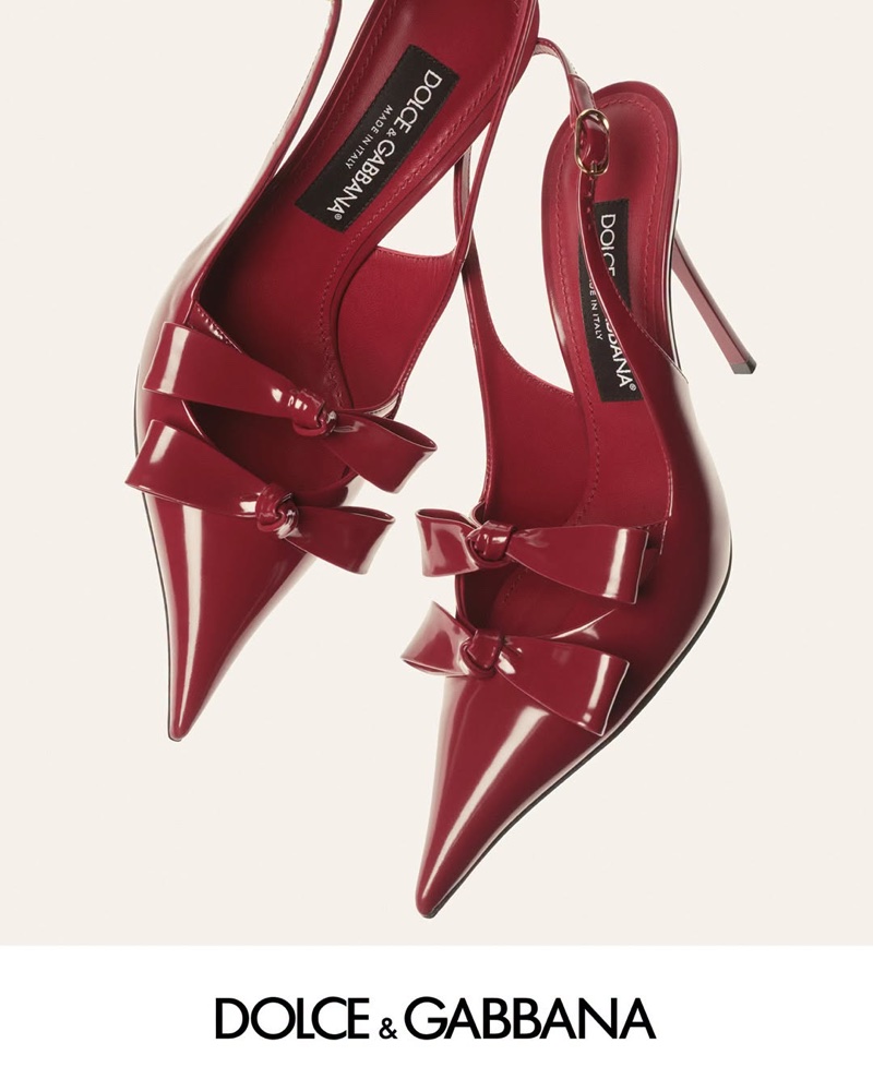 Two red patent leather slingback heels with double bows against a clean light background for Dolce and Gabbana