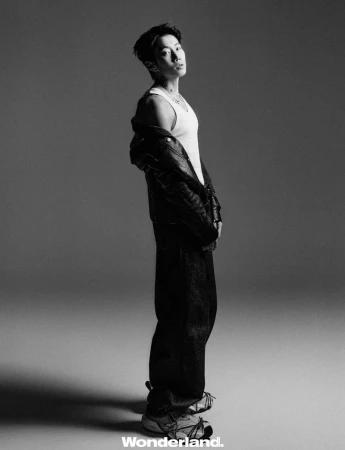 Black and white editorial portrait of Jay Park wearing a white tank top and leather jacket against a grey studio backdrop.