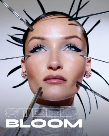 Close-up beauty portrait of a woman surrounded by metallic makeup spatulas, wearing blue eye makeup against a pale background.