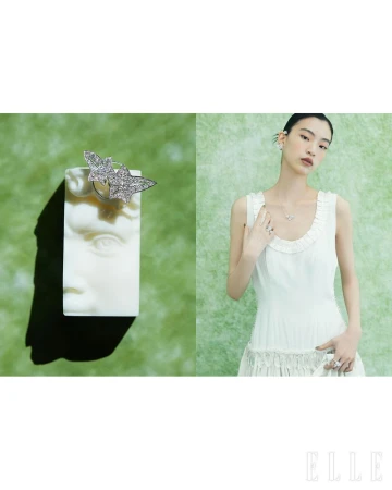 East Asian model in a white dress wearing diamond jewelry beside a white plaster bust showcasing a diamond leaf ring.