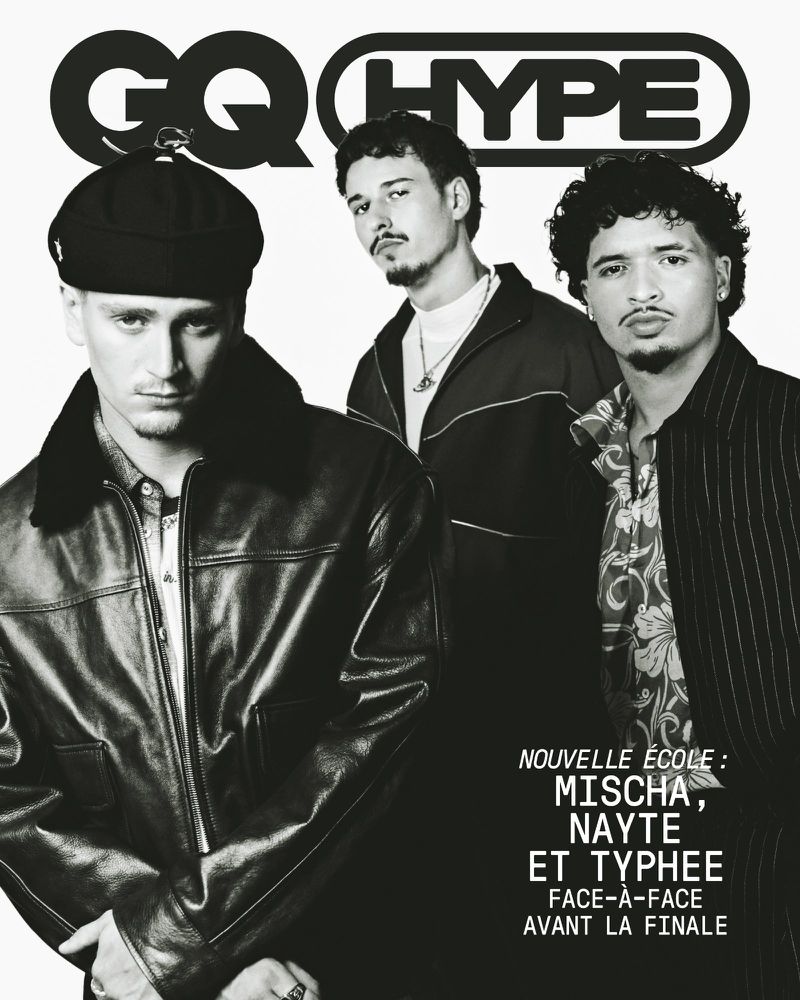 Three young men posing for a black and white GQ Hype cover, with the foreground subject wearing a leather bomber jacket and cap.