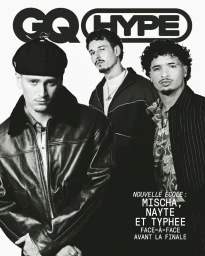 Three young men posing for a black and white GQ Hype cover, with the foreground subject wearing a leather bomber jacket and cap.