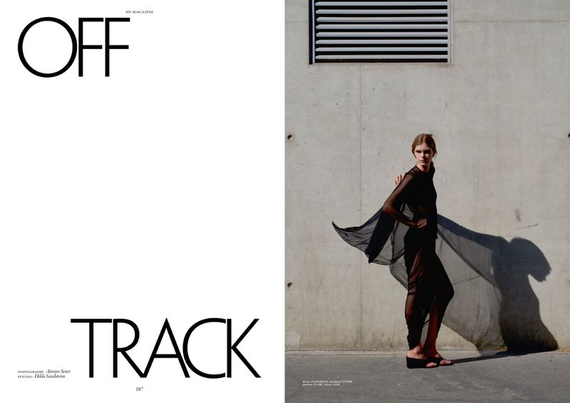 Editorial spread featuring typography OFF TRACK beside a model in a sheer black ensemble against a concrete wall.