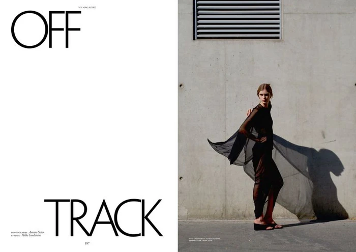 Editorial spread featuring typography OFF TRACK beside a model in a sheer black ensemble against a concrete wall.