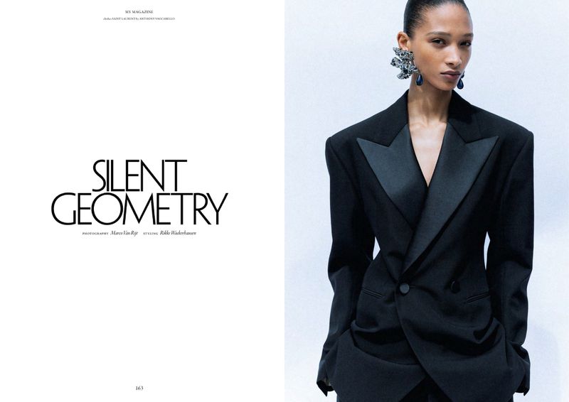 Model Elodie Guipaud wearing a structured black tailored blazer with satin lapels in an editorial layout beside typography text.