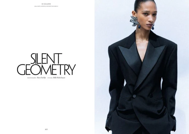 Model Elodie Guipaud wearing a structured black tailored blazer with satin lapels in an editorial layout beside typography text.