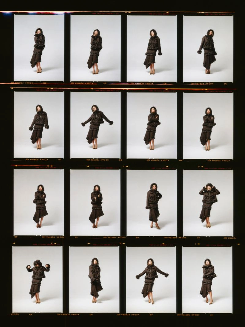 A film contact sheet featuring sixteen individual frames of Jodie Comer posing in a dark layered outfit against a studio backdrop.
