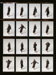A film contact sheet featuring sixteen individual frames of Jodie Comer posing in a dark layered outfit against a studio backdrop.