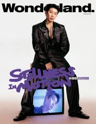 Jay Park seated in a shimmering black suit behind a CRT television displaying his face on a Wonderland China magazine cover.