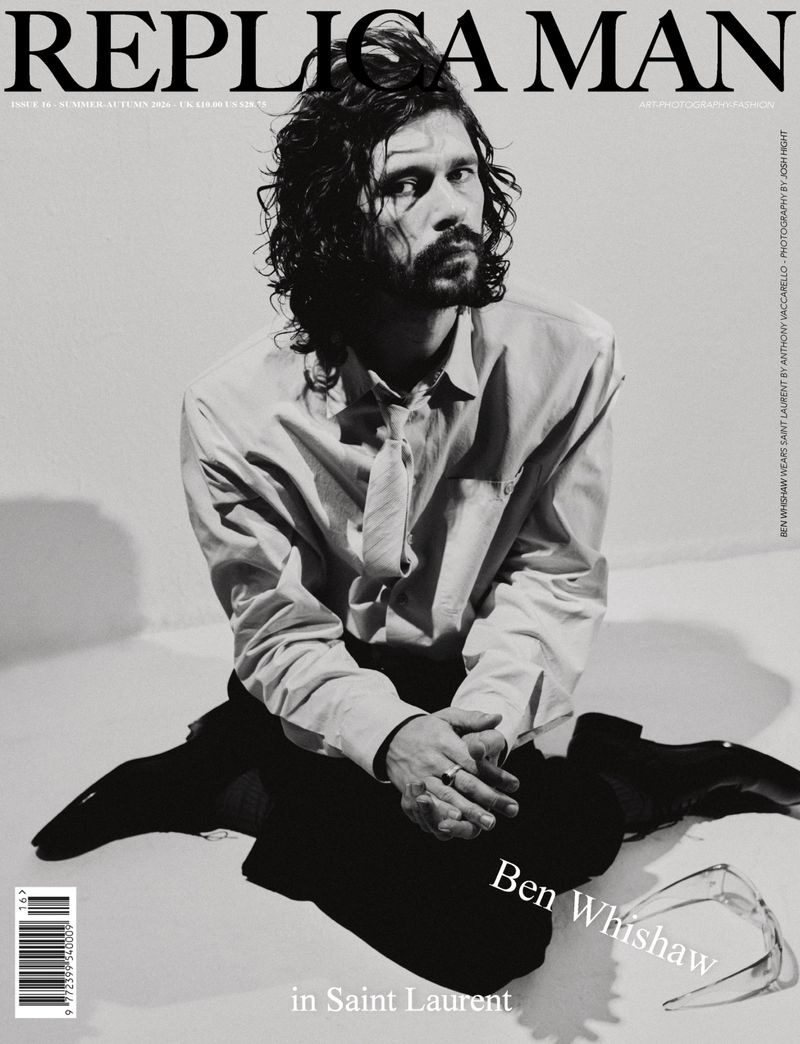 Actor Ben Whishaw seated on the floor wearing a collared shirt, tie, and dark trousers for Replica Man Magazine cover.