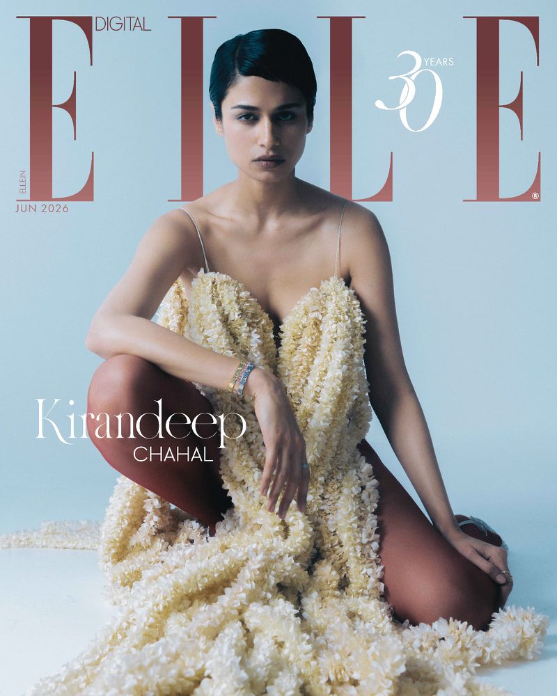 Model Kirandeep Chahal seated in a textured cream dress and rust-toned tights against a pale blue backdrop on the Elle India cover.
