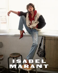 Model Mathilda Gvarliani perched on a stool wearing a color-blocked jacket, blue jeans, and red heels for Isabel Marant.