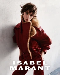 Model Mathilda Gvarliani wearing a red leather jacket with fur collar against a grey wall for Isabel Marant Fall-Winter 2026 Campaign