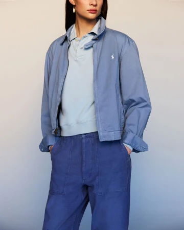 Woman in blue jacket and pants. She's indoors with light complexion and dark hair. Fashion shot.