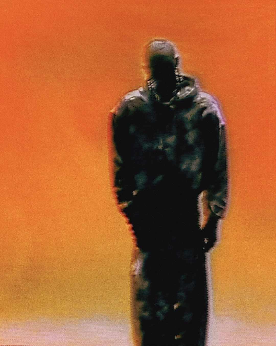 Grainy silhouette of a figure in an oversized hoodie standing against a vibrant orange and amber gradient background.