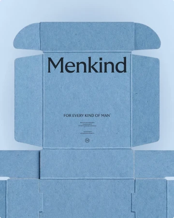 Unfolded light blue textured cardboard packaging box with printed Menkind branding against a pale background.
