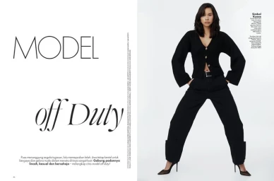 Model wearing a black cardigan and black trousers posing against a white seamless studio background for Elle Malaysia editorial.