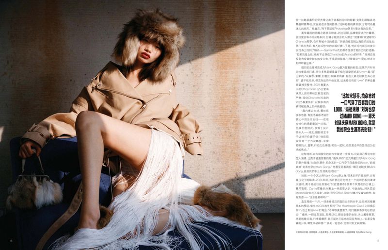 An adult woman in a fur hat and jacket poses seated with a purse. She wears a dress with tassels indoors, sitting in sunlight.
