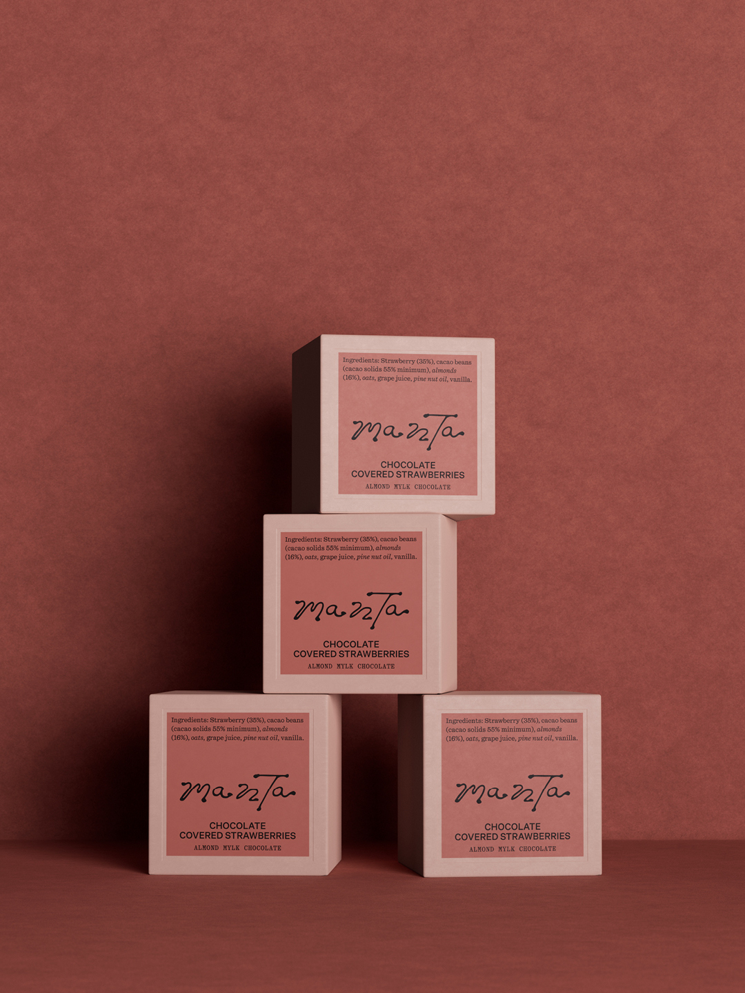 Four square Manta chocolate packaging boxes stacked symmetrically against a warm textured terracotta background.