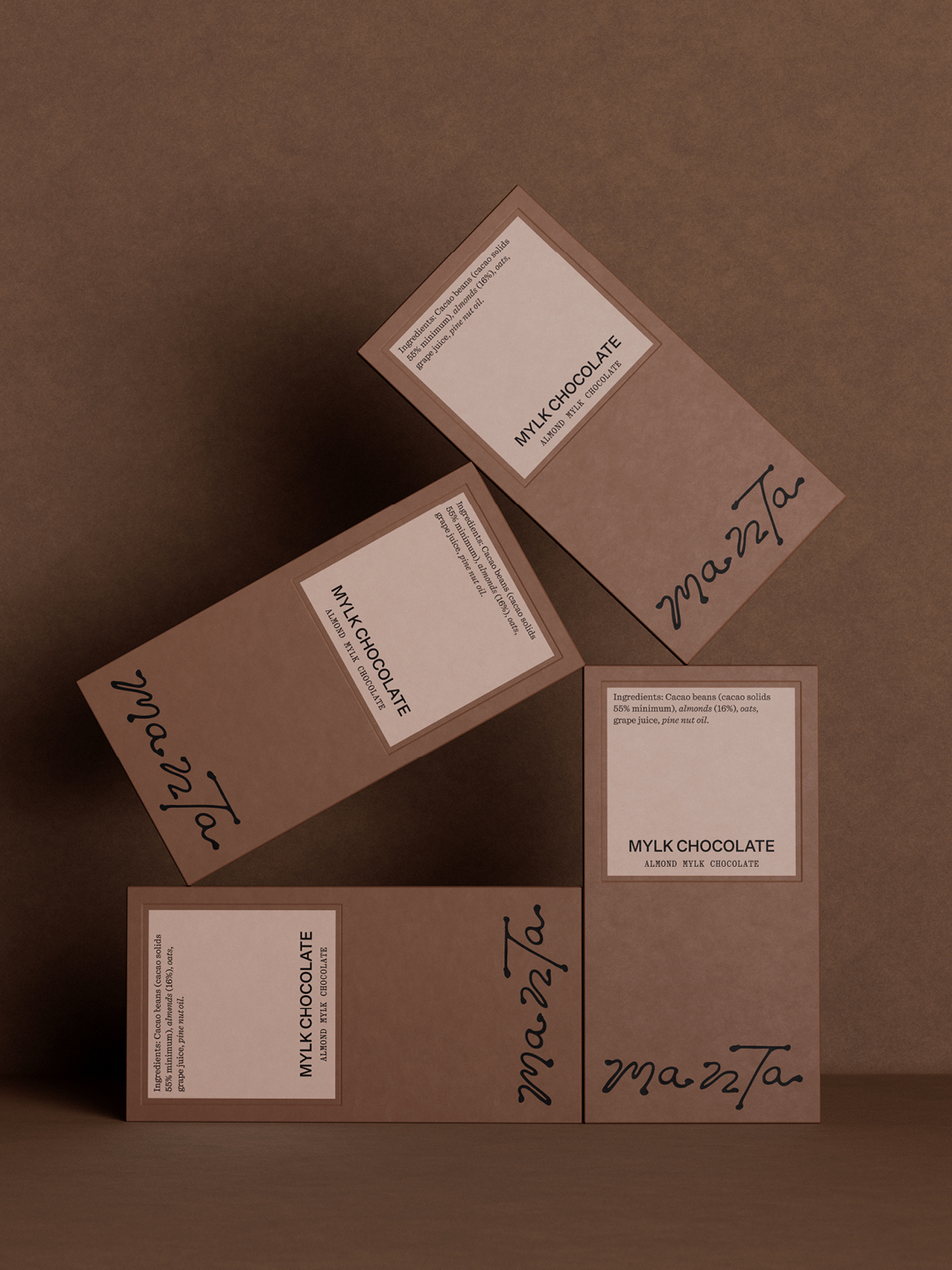 Four Manta mylk chocolate packaging boxes arranged artistically on a brown textured surface.