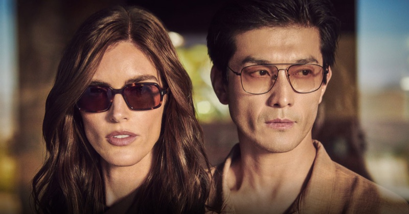 Close-up portrait of a woman and a man wearing designer sunglasses outdoors in soft warm light for Oliver Peoples.