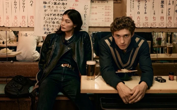 Two models seated at a restaurant table with a beer and noodles, in a campaign for Banana Republic photographed by Sonia Szostak.