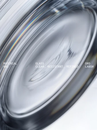 Extreme close-up macro view of thick curved glass surface with subtle prismatic light refractions and clean typography layout.