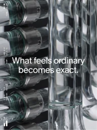 Close-up vertical shot of intricate glass and metallic cylindrical engineering components with text overlay