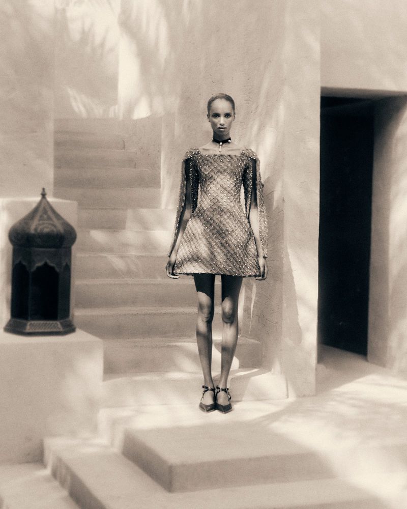 Model Bibi Abdulkadir in a structured mini dress standing by plaster stairs for Vogue Czechoslovakia editorial.