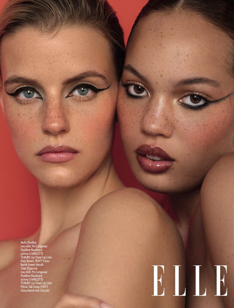 Close-up of two women with eye makeup and nude makeup on a red background, fashion beauty shot.