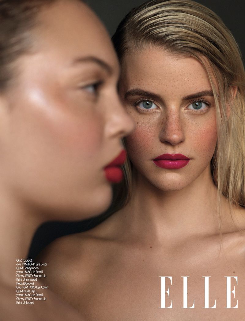 Close-up beauty portrait of two women, one in profile with red lips and one facing forward with freckles and magenta lipstick.