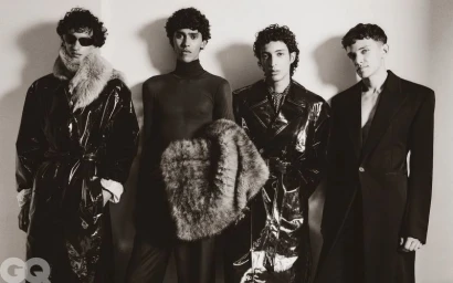 Four male models posing together in Saint Laurent menswear against a plain wall for GQ Middle East editorial photography.
