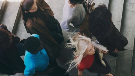 High-angle view of a diverse group of models walking up grey stone stairs for Zara Pre-owned