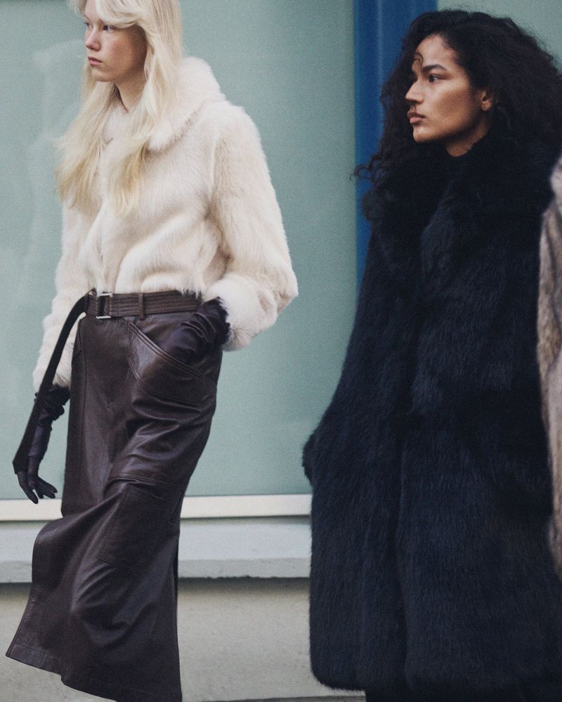 Two models wearing winter coats and leather gloves posing outdoors for Zara Pre-owned