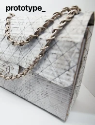 Prototype quilted handbag with silver chain strap against a plain white background