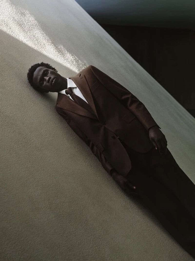 Man wearing a brown suit and white shirt posing against a textured concrete wall for Fursac F/W 2026 campaign