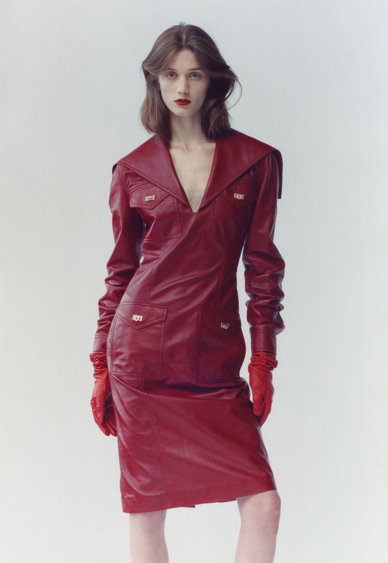 Model wearing a deep red leather dress and matching red gloves against a white background for The Blend Magazine.