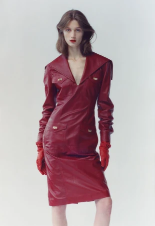Model wearing a deep red leather dress and matching red gloves against a white background for The Blend Magazine.