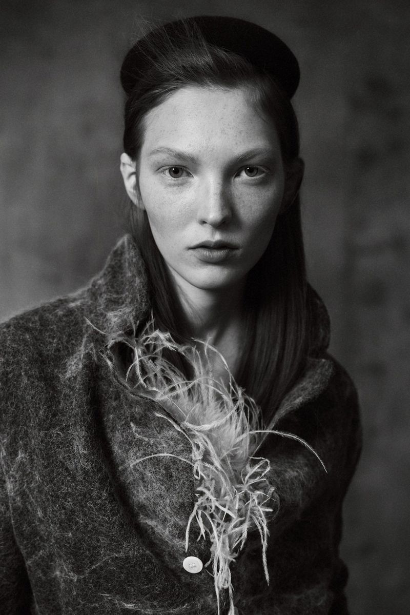 Portrait of a female model wearing a textured jacket and headband in a monochrome fashion editorial for Elle Hungary.