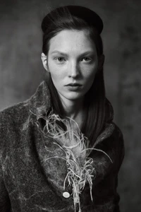 Portrait of a female model wearing a textured jacket and headband in a monochrome fashion editorial for Elle Hungary.