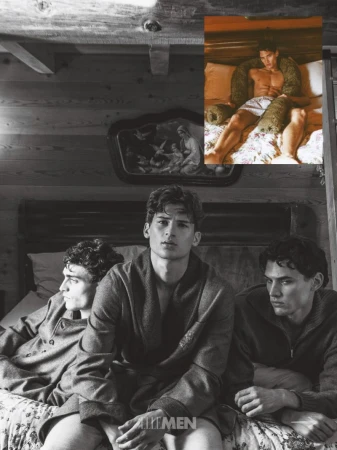 Three male models in robes and knitwear seated on a bed inside a wood paneled room with inset color inset photo above.