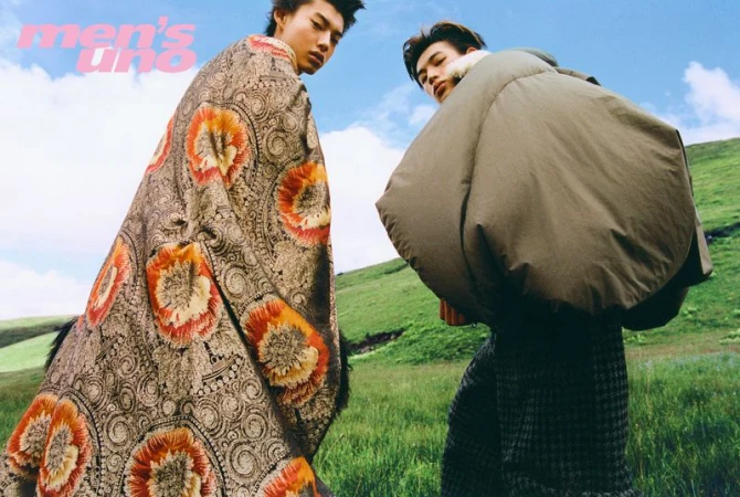 Two male models in textured garments on a grassy hillside under an open sky for Men's Uno China.