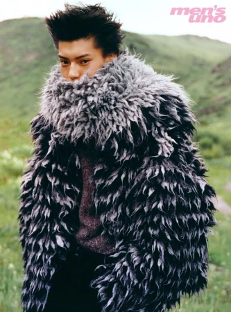 Model Yq in a heavy textured black and grey winter coat standing in a lush green outdoor landscape for Mens Uno China