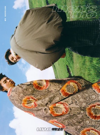Low-angle shot of a male model outdoors against a green landscape and blue sky wearing patterned clothing for Men's Uno China.