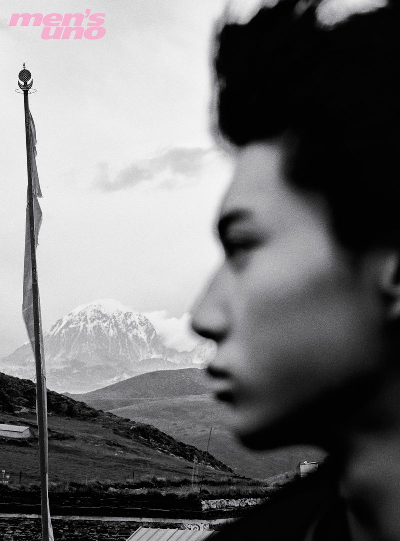 Black and white portrait of a man in profile with a mountain landscape and flagpole in the background