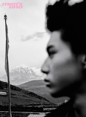 Black and white portrait of a man in profile with a mountain landscape and flagpole in the background