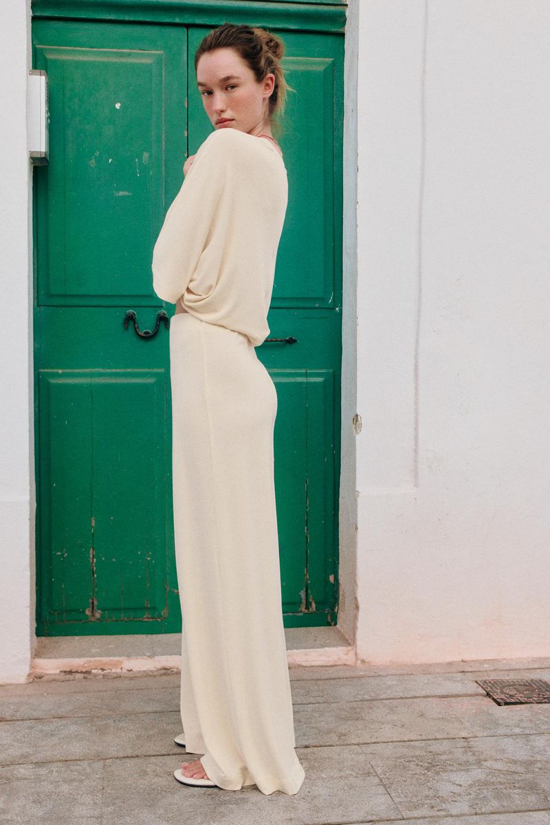 Model Jenn du Puy wearing a cream knit outfit posing against a green door for Zara, photographed by Paolo Steve.
